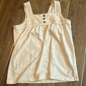 Cream colored top with 3 finger strap and 3 buttons on the front, soft material